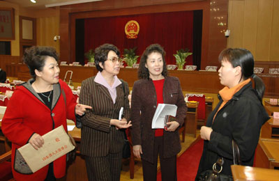 Chinese lawmakers Guo Yuejin, Jiang Jian, Shao Fengjing and Lin Weining (from left to right) chat in a meeting room in Jinan, East China's Shandong Province March 1 before leaving for Beijing for the annual session of the National People's Congress. China's top legislature is to convene Monday. [newsphoto]