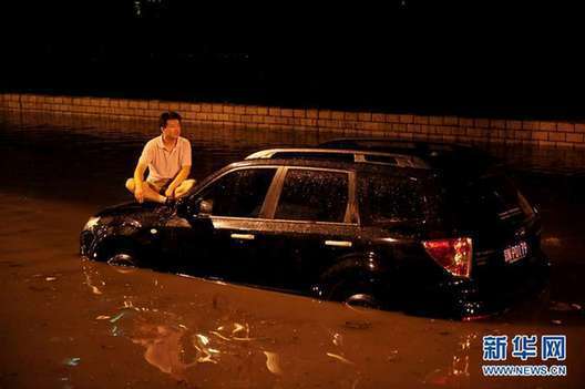 北京夜降暴雨 積水中勇現(xiàn)“淡定哥”(組圖)