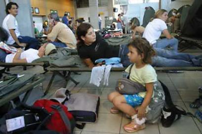 French nationals wait for flights out of the Ivory Coast in the passenger hall of the international airport at Abidjan on November 10, 2004. France was preparing to airlift citizens from its former colony after more than 2,000 French and foreign nationals were chased from their homes by violent mobs loyal to Ivory Coast President Laurent Gbagbo. [Reuters]