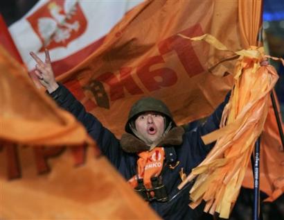 A supporter of Ukrainian opposition leader Viktor Yushchenko wearing a military helmet shouts during a rally in Kiev's main Independence Square Monday, Dec. 27, 2004, with a Polish flag at the background. Yushchenko celebrated his apparent victory in Ukraine's presidential election Monday, thanking his supporters for spending weeks camped out on freezing streets in a show of force that helped overturn results of a previous round marred by fraud. [AP]