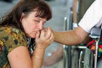 Hannala Zirath from Sweden holds her husband's hand after they were reunited December 28, 2004 following a tsunami which hit the Thai resort island of Phuket. Zirath's husband, who was injured by huge tidal waves was being airlifted to Bangkok for treatment. Nations on the Indian Ocean from Indonesia to Sri Lanka struggled on Tuesday to find and bury their dead and help the survivors of tidal waves as fears grew the final toll would far exceed the 27,700 people reported killed. [Reuters]