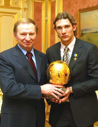 Outgoing Ukrainian President Leonid Kuchma (L) poses with AC Milan's striker Ukrainian Andriy Shevchenko, holding the Golden Ball award for the Europe's best soccer player, during a ceremony in Kiev, December 31, 2004. Kuchma on Friday presented Shevchenko with the order of Hero of Ukraine.