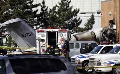 A corporate jet that skidded off the runway during takeoff lies with its cockpit and a car it hit embedded in the side of a warehouse across the street from Teterboro Airport in Teterboro, New Jersey, after the accident February 2, 2005. [Reuters]