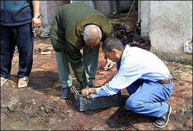 Iraqis collect belongings of victims caught in a bomb, off the blood stained sidewalk following a car bomb, in the southern city of Hilla, the capital of Babylon province, 100 kms south of Baghdad. A suicide bomber killed 114 people and wounded scores more when he blew up his car in the middle of a crowd outside a health clinic in central Iraq (news - web sites), in one of the deadliest attacks since the US-led invasion two years ago.(AFP/Qassem Zein) 