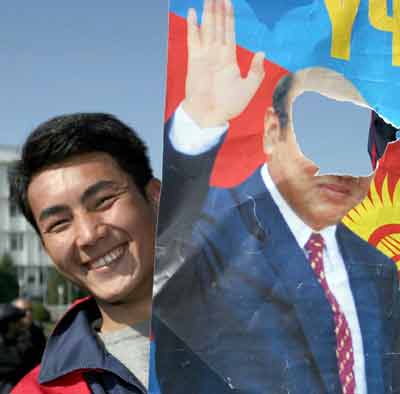 An opposition protester holds up a torn portrait of Kyrgyz President Askar Akayev during a rally in the centre of Osh, March 22, 2005. Opposition protesters hold two southern Kyrgyzstan's towns Osh and Jalal Abad, as they maintain pressure on President Akayev who has pledged to hold talks to defuse the crisis fuelled by row over the outcome of parliamentary polls. [Reuters]