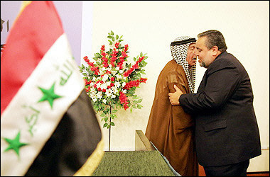 Outgoing Interim Industry Minister Hajem al-Hassani (R) is embraced by outgoing speaker Dhari al-Fayad as he walks onto the platform after the National Assembly voted him in as the new speaker, in Baghdad's fortified Green Zone.(AFP/Karim Sahib)