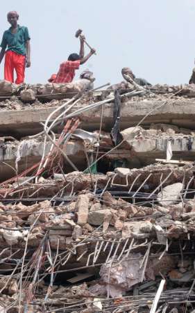 Rescue workers break through debris of a collapsed nine-story garment factory near Dhaka April 12, 2005. Rescuers in Bangladesh were trying on Tuesday to reach up to 150 people trapped in a rubble after a nine-story garment factory collapsed near the capital killing at least 26, officials said. REUTERS/Rafiqur Rahman 