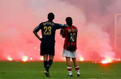 Inter Milan's Marco Materazzi (L) and AC Milan's Manuel Rui Costa wait on the pitch as supporters throw flares during their Champions League quarter-final second leg soccer match at the San Siro Stadium in Milan April 12, 2005. The Champions League quarter-final was abandoned after 73 minutes after Milan's goalkeeper Dida was hit by one of dozens of flares thrown on the pitch. Photo by Stefano Rellandini/Reuters 