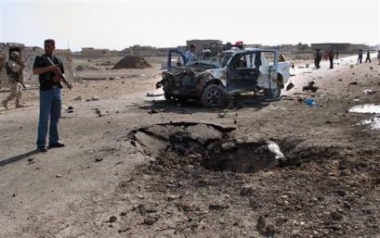 Iraqi police secure the area after a suicide attacker blew up an ambulance packed with explosives near a police special forces patrol, killing four Iraqis, including two policemen in the outskirst of Baqouba, 130 kms (80 miles) north of Baghdad, Iraq, Friday, April 29, 2005. (AP 