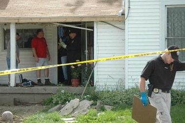 Crime scene investigators work on the porch of a farmhouse, one of two neighboring farmhouses where six people, including two children, were found shot to death near Bellefontaine, Ohio, Sunday, May 29, 2005. 