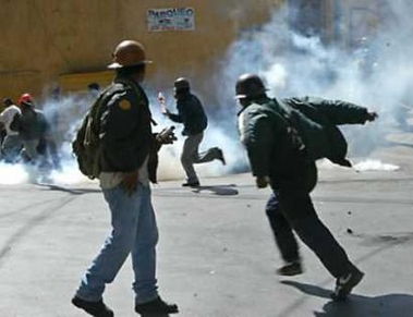 Bolivian workers of Caracoles mine run from tear gas during protests in La Paz June 7, 2005. Tens of thousands of Bolivian peasants and miners marched through La Paz on Tuesday despite President Carlos Mesa's offer to resign as some opposition leaders urged early elections to end the crisis gripping the country. (Jose Miguel Gomez/Reuters)