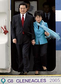 Chinese President Hu Jintao (L) and his wife Liu Yongqing arrive at Prestwick airport in Scotland for the G8 Summit at Gleneagles, Scotland, July 6, 2005. Aid, debt relief and climate change top the agenda for leaders of the G8 -- the Group of Seven industrialised nations plus Russia -- who are meeting for three days from Wednesday in Gleneagles, Scotland. The leaders will also discuss rising oil prices and their implications for global growth. [Reuters]