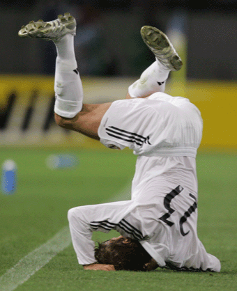 Real Madrid's David Beckham rolls over after being tackled by Tokyo Verdy's Kenichi Takahiro Soma during their friendly match at Ajinomoto Stadium in Tokyo July 25, 2005. Real Madrid suffered an embarrassing 3-0 defeat by Tokyo Verdy on Monday in the first of two pre-season games in Japan.