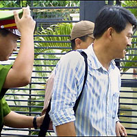 A policeman escorts Vu Tien Thanh (R), manager of the leading Vietnamese football club Dong A, out of his residence in Ho Chi Minh City, 30 August, as he is arrested pending inquiries into match-fixing allegations. 