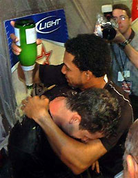 Houston Astros infielder Chris Burke (L) is doused with champagne by team mate Willy Taveras in the locker room after Burke hit a solo homerun in the 18th inning to defeat the Atlanta Braves 7-6 in Game 4 of the National League Division Series in Houston, Texas, October 9, 2005. 