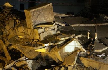 A man with white gloves stands atop the debris of Margala Towers and rises his hands to singnal for silence from all those around the debris of Margala Towers, during the rescue of a two-year old boy and a woman by a British 'RAPID UK Search and Rescue' team after Saturday's earthquake, in Islamabad on Monday, Oct. 10, 2005. (AP