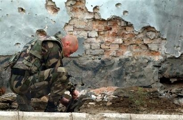 A French soldier of International Security Assistant Force (ISAF) checks the rocket at the landed site in Kabul, Afghanistan on Wednesday, Oct. 12, 2005.