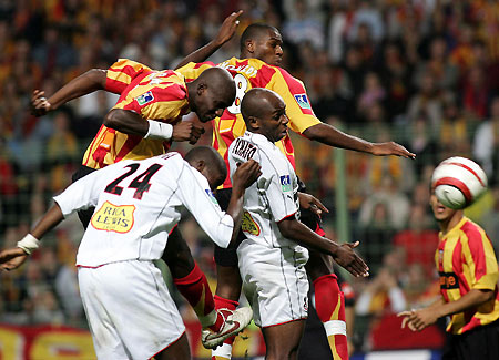 Racing Lens' Alou Diarra (top L) jumps with team mate Adama Coulibaly (top C ) to score on goal against Nice's Rod Fanni (L) and Bill Tchato Mbiayi (C) during their French Ligue 1 soccer match at the Bollaert Stadium in Lens, northern France October 15, 2005.