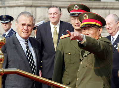 Chinese Defense Minister Cao Gangchuan (right) gestures at a welcoming ceremony hosted in the honour of visiting US Defense Secretary Donald Rumsfeld in Beijing October 19, 2005. [newsphoto]