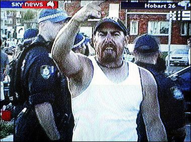 An image from Australia's Sky News shows a man shouting as police stand by to quell racial violence which erupted on Sydney beaches on Sunday.