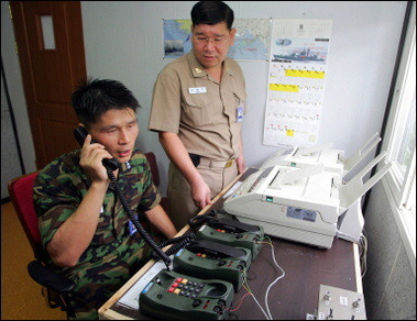 A South Korean soldier talks to a northenr counterpart. South and North Korea have opened cross-border commercial communications lines for the first time since their division in 1945