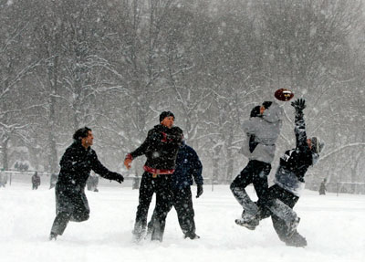 People play a game of football in New York's Central Park during a snowstorm February 12, 2006. The biggest snowstorm of the season belted the northeastern United States on Sunday with whiteout conditions and flashes of lightning, forcing airports to close, snarling traffic and bringing joy to ski resorts. As much as 22.8 inches (57.9 cm) of snow fell in New York's central park, the second heaviest snowfall on record, topped only by a blizzard in 1947, said the National Weather Service.