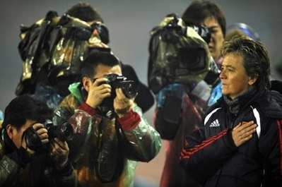 This photo taken on February 18 shows China's French coach Elisabeth Loisel (R) listens to the national Anthem before China plays against S. Korea in the East Asian Women's Football Championships. The coach of China's women's football team has insisted they remain on target for a medal at the Beijing Olympics, despite a 3-0 loss to Japan. [Agencies]