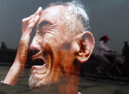 A cyclist is reflected on a photograph of war survivior Yu Huishui which is on display at Marco Polo Bridge on the outskirts of Beijing July 6, 2007, on the eve of 70th anniversary of Japan's full-scale invasion of China. The exhibit coincides with the 70th anniversary of the July 7, 1937 skirmish at the Marco Polo Bridge near Beijing, which sparked an all-out war between China and Japan.[Reuters]