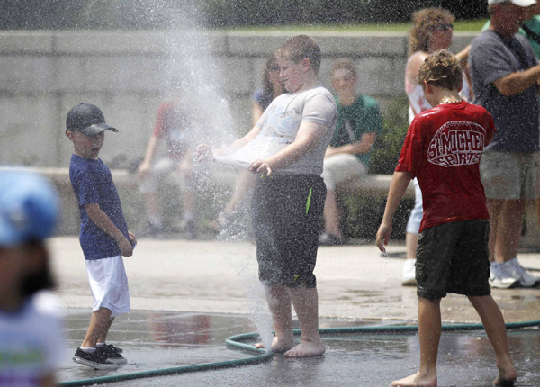 Children play with sprays of water in Washington