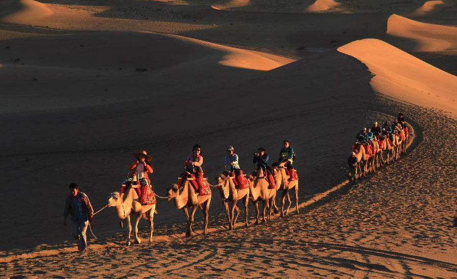 Tourists visit Mingsha Mountain in Dunhuang