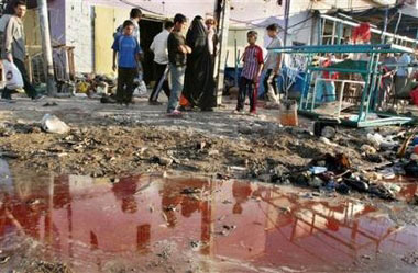 Residents walk past the scene after suspected insurgents set off a bomb near a food stand where men gathered to wait for jobs as day laborers in the Sadr City area of Baghdad, Iraq Saturday, May 20, 2006. The bomb killed 19 people and wounded 58, as the Iraqi parliament prepared to inaugurate the country's first fully constitutional government since the collapse of Saddam Hussein's regime three years ago. [AP Photo]